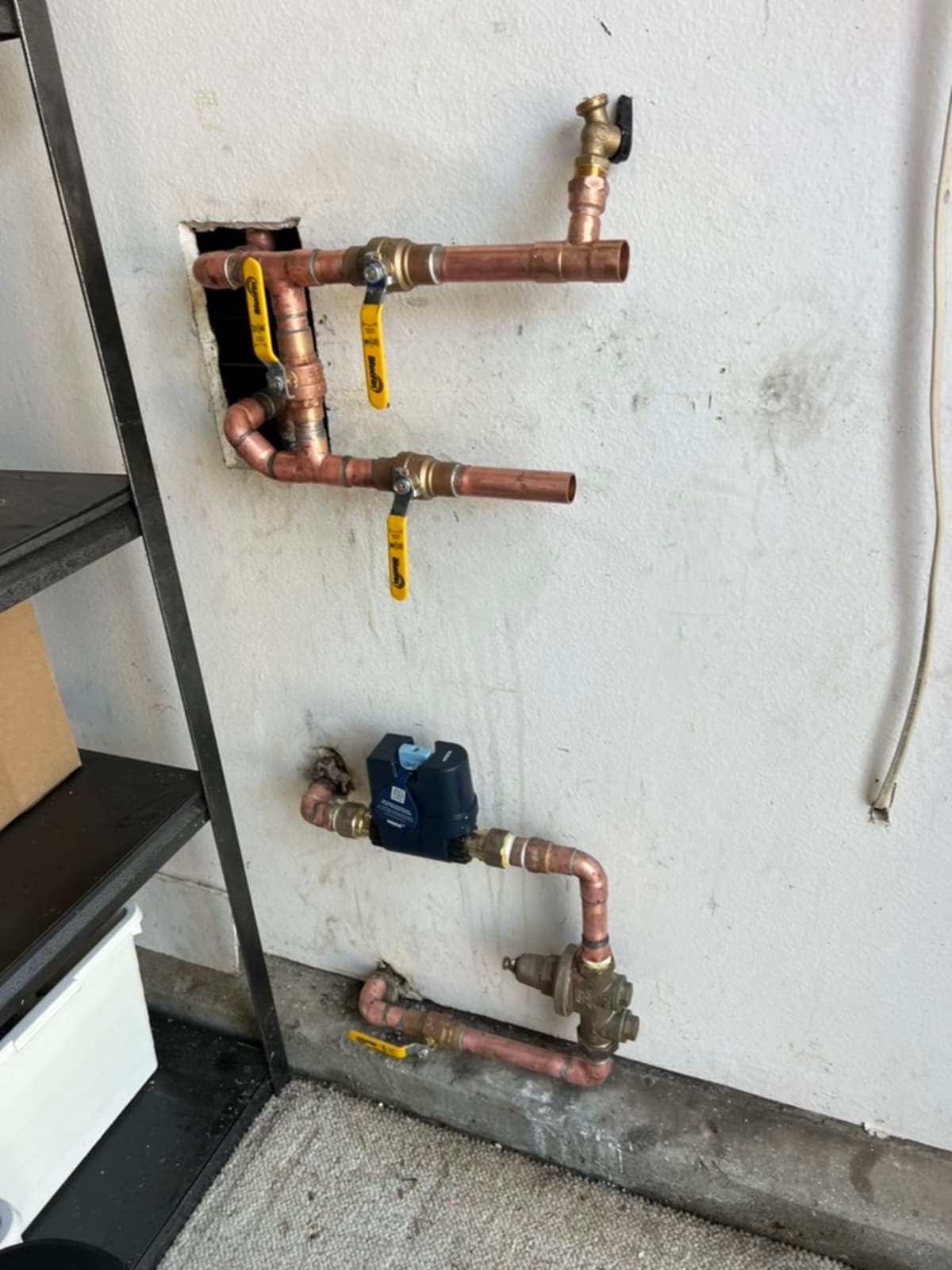 Copper manifold with ball valves and smart water monitor in garage